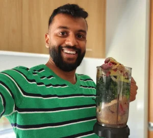 Opi Holding a Large Nutribullet Cup full of Fruits and Veggies